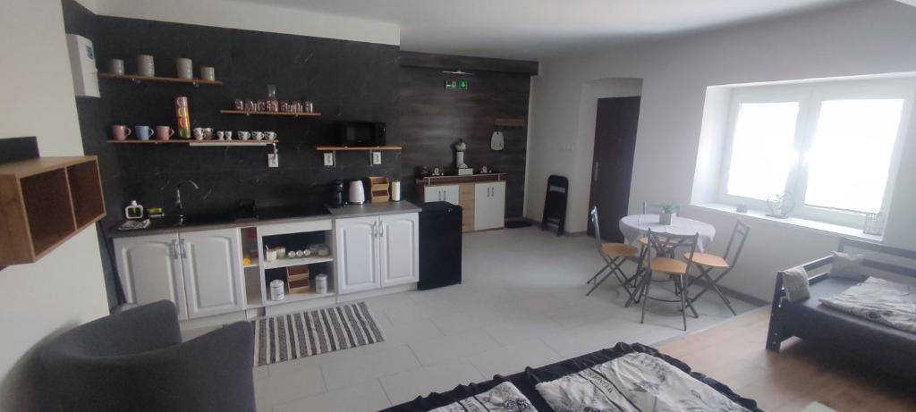 a living room with a kitchen and a table with chairs at Apartmán Domča in Banská Štiavnica