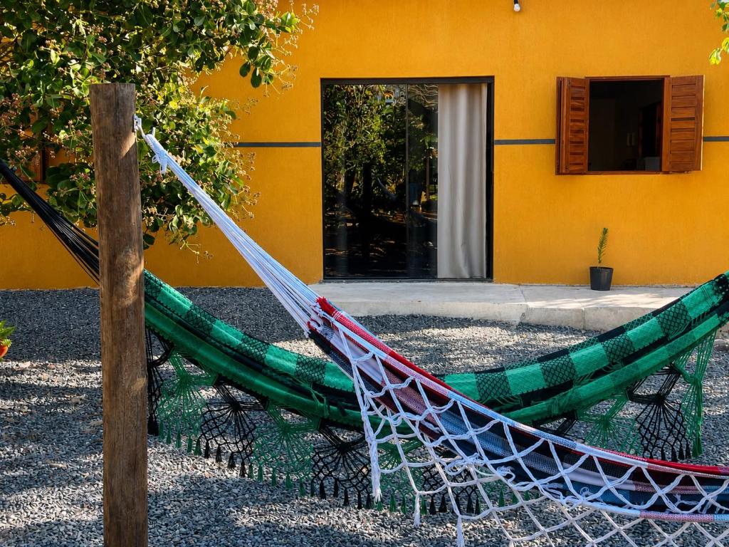 a hammock in a yard in front of a building at Chácara Orvalho da Chapada in Cavalcante