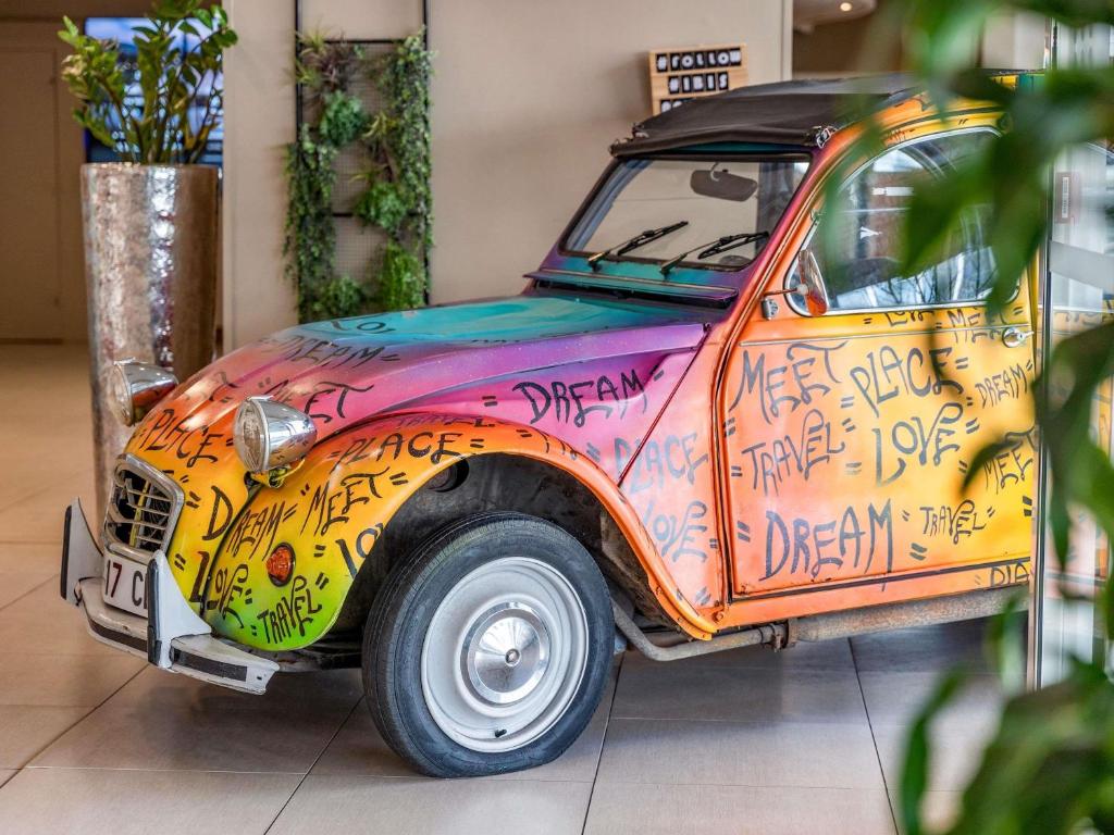 a car covered in graffiti parked in a room at ibis Paris 17 Clichy-Batignolles in Paris