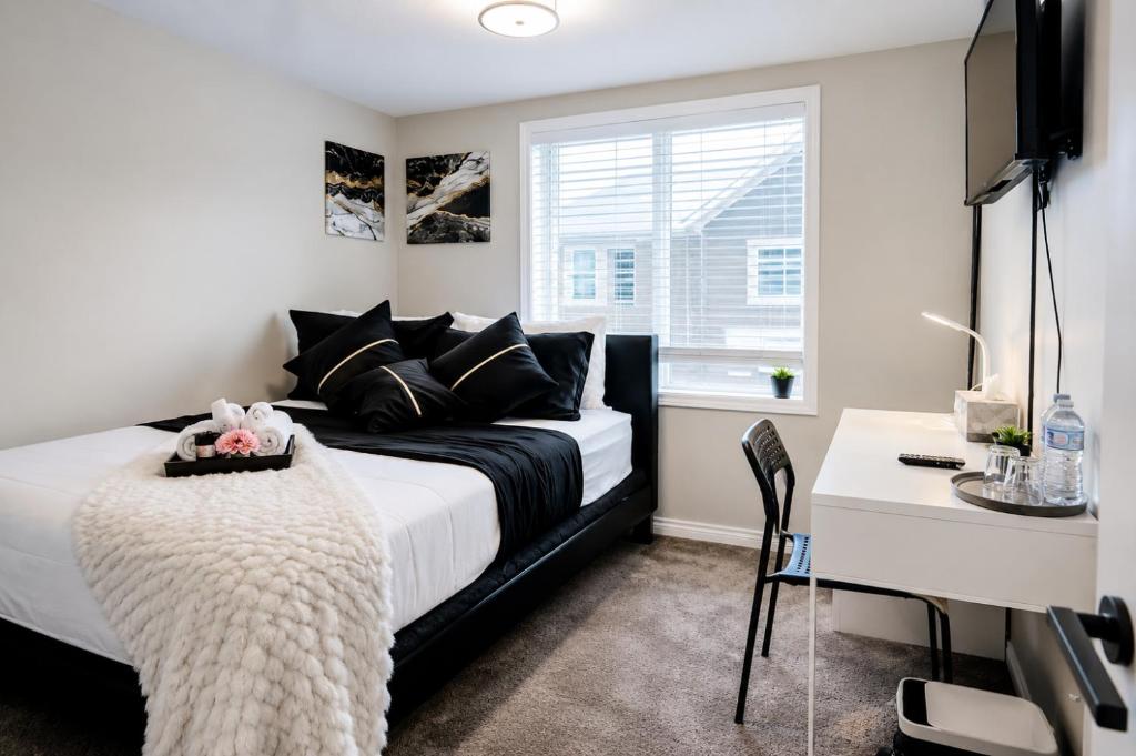 a bedroom with a black and white bed and a desk at Southside Haven Edmonton in Edmonton
