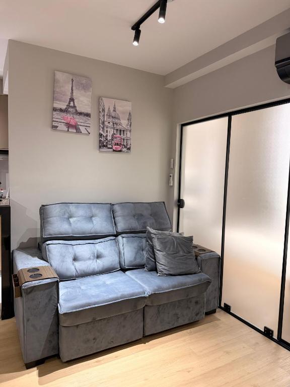 a living room with a couch in a room at Apê 64 Bela Vista com ar condicionado e garagem in Espirito Santo Do Pinhal