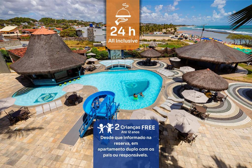a swimming pool with umbrellas and chairs and a resort at El Aram Beach Cabo - All Inclusive in Cabo de Santo Agostinho