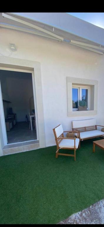 a room with two chairs and a couch and green carpet at Casa mariano in Marconia