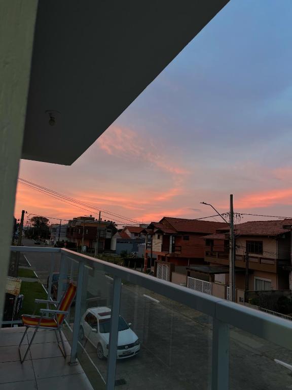 a view of a sunset from a balcony with a car at Apartamento em Garopaba in Garopaba