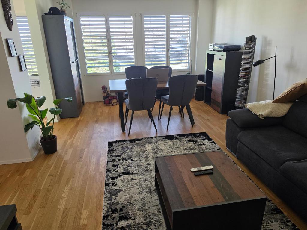 a living room with a couch and a table and chairs at Sonnige Wohnung in Grenchen