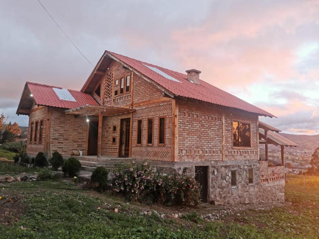 a wooden house in the middle of a field at Pakarina WASY in San Miguel