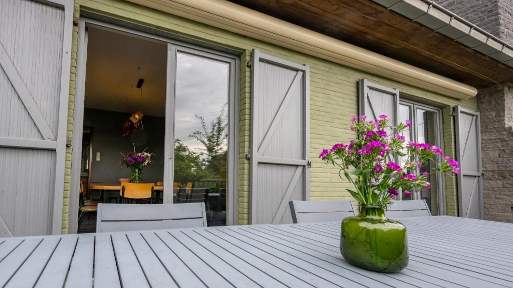 a vase with flowers on a table on a patio at Lumen nr5 in Bois