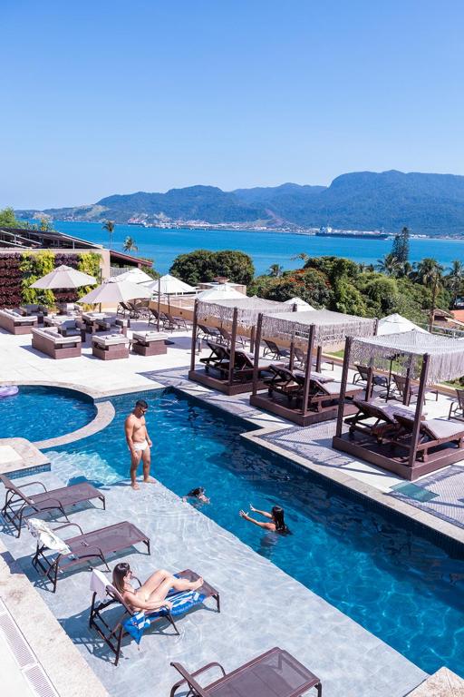 a group of people in the swimming pool at a resort at Ilhabela Beach Residences in Ilhabela