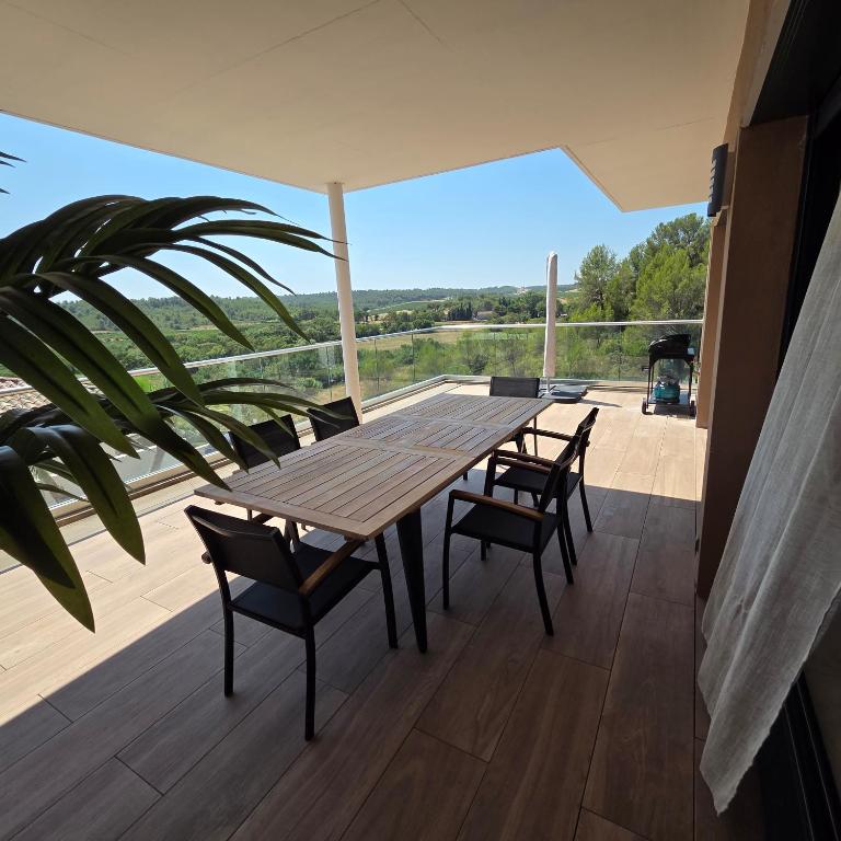 a wooden table and chairs on a deck at Villa View in Combaillaux
