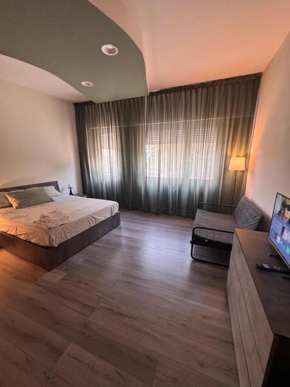 a bedroom with a large bed and a couch at Le due dimore del Baluardo in Novara