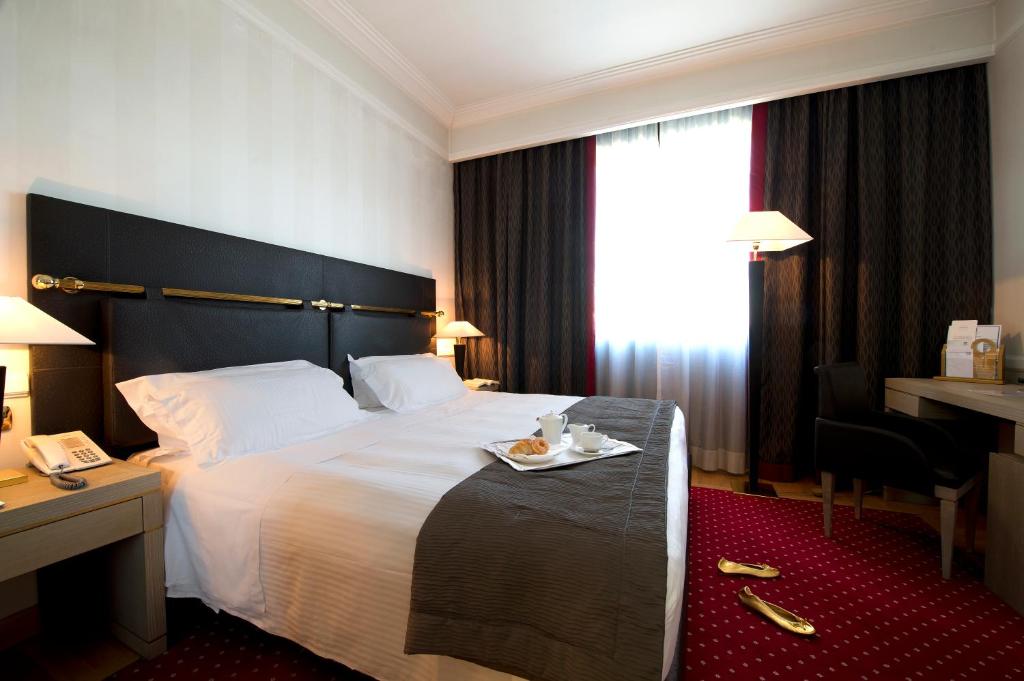 a hotel room with a bed with a tray of food on it at Grand Hotel Duca Di Mantova in Sesto San Giovanni