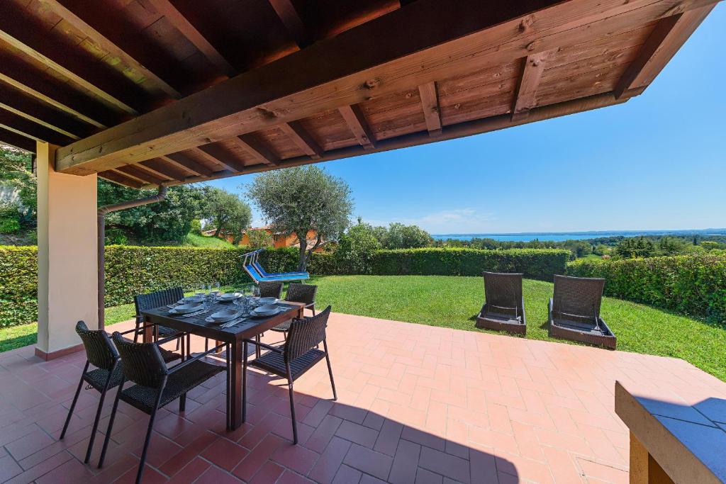 a patio with a table and chairs under a pergola at Borgo Stropea by Whale Homes in Soiano del Lago