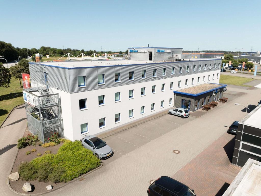a white building with cars parked in front of it at ibis budget Flensburg Handewitt in Handewitt