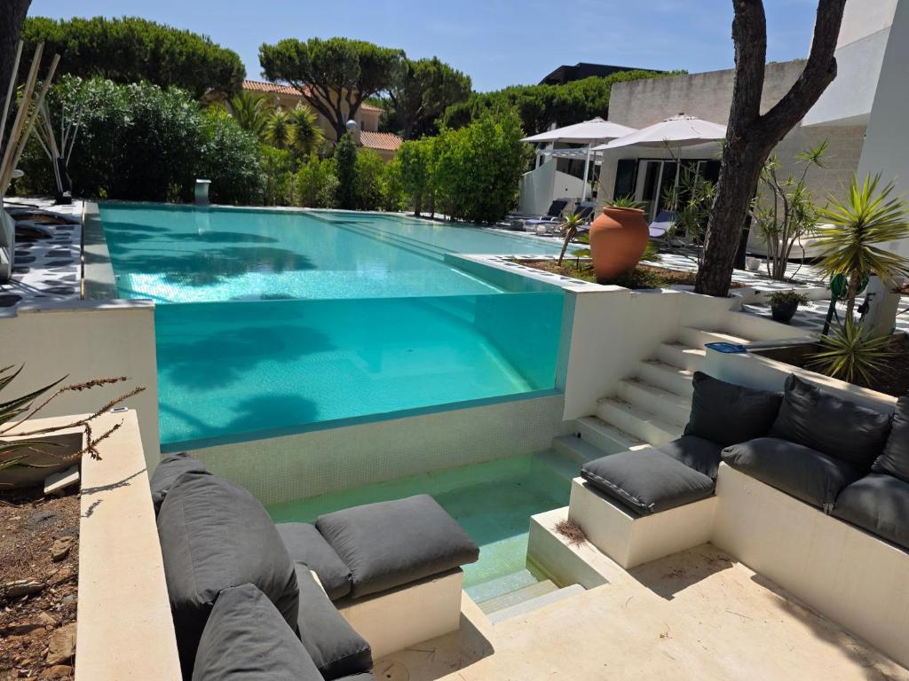 a swimming pool with blue water in a yard at CASA DOS CATOS in Praia Verde