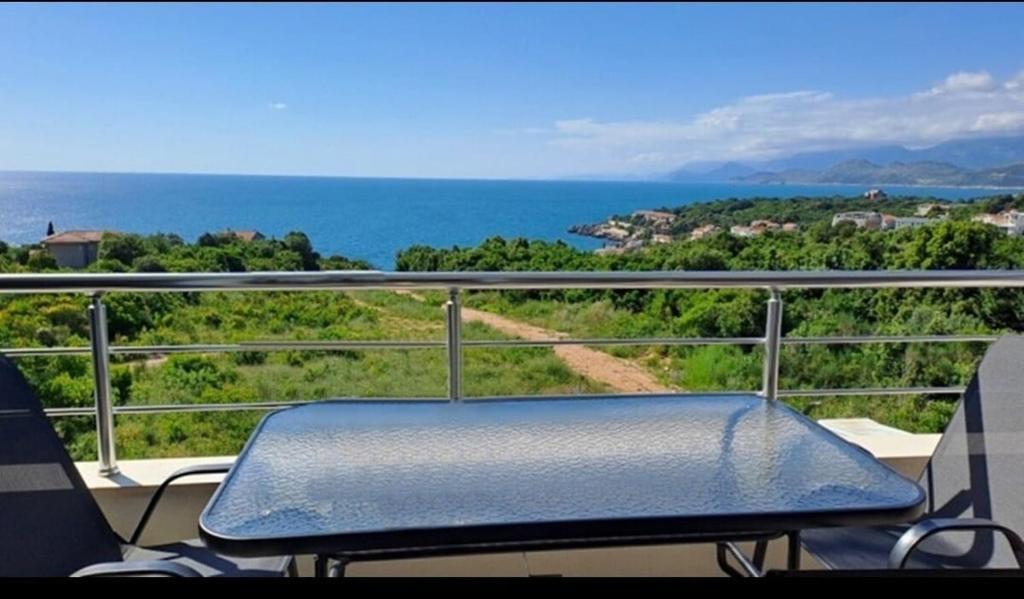 a blue bench on a balcony with a view of the ocean at Ninas Seaview Apartment in Bar