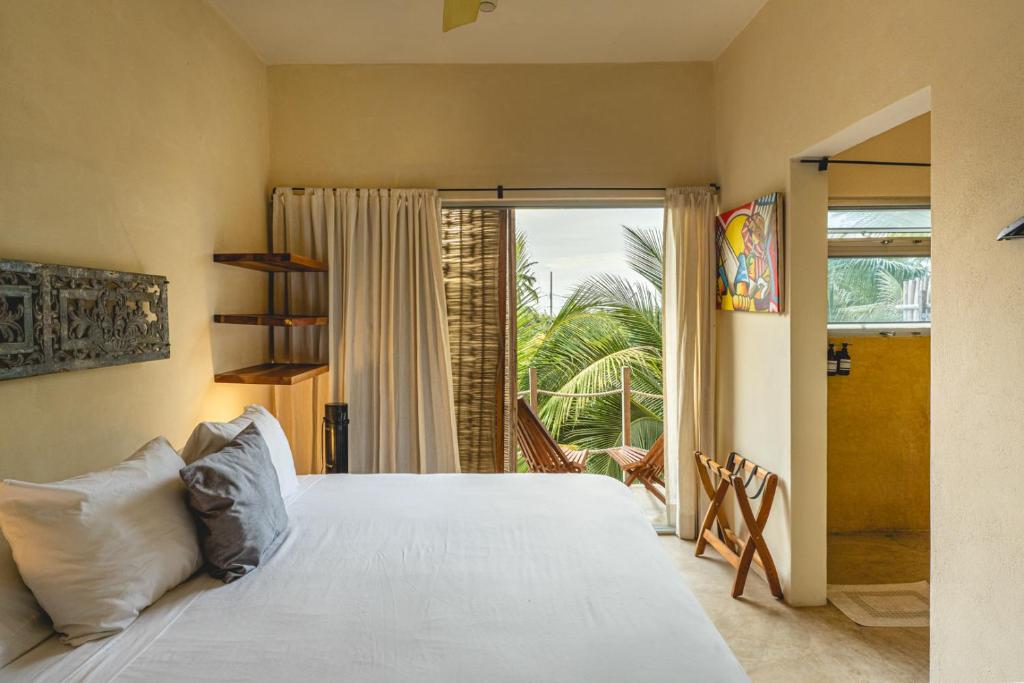 a bedroom with a large white bed and a window at Casa Mia El Cuyo Eco Beach Boutique Hotel Sin Aire Acondicionado in El Cuyo