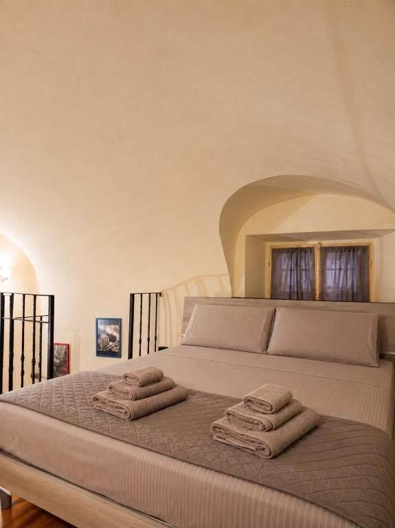 a bedroom with a bed with two towels on it at Living Adua Centro in Tortona