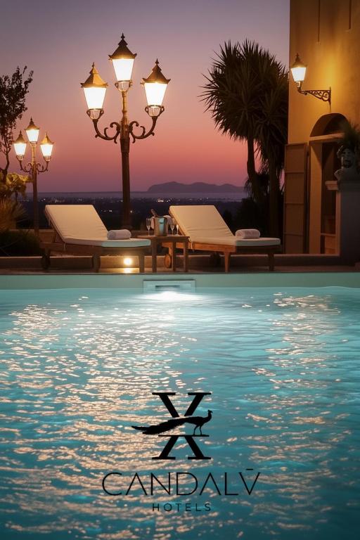 a picture of a pool with a sunset in the background at Candalù - Villa Giardinata in Valderice