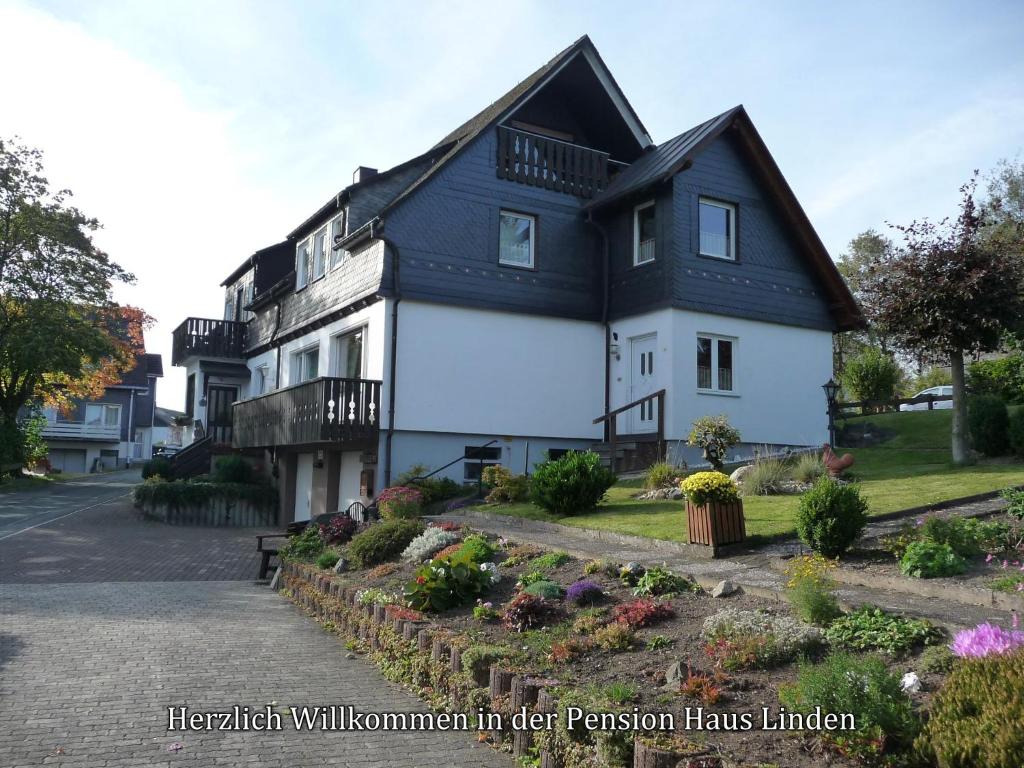 a large white house with a black roof at Pension Haus Linden in Winterberg