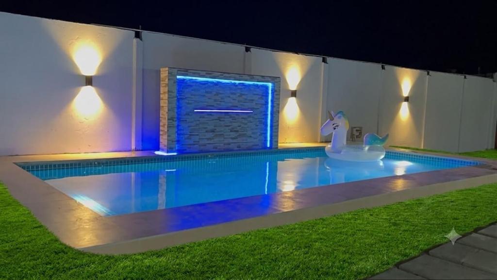 a swimming pool at night with a lit upescriptionsenalsenalsenalsenal at Villa Arcoíris in Paita