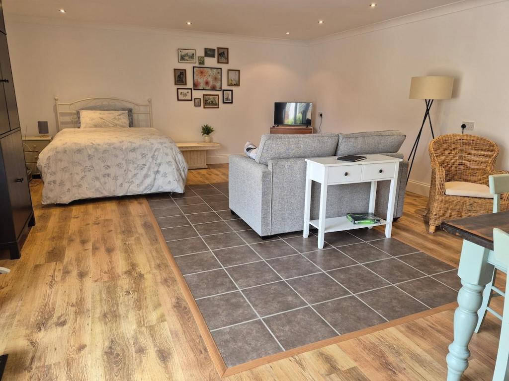 a bedroom with a bed and a couch and a table at Highlands in Pinchbeck