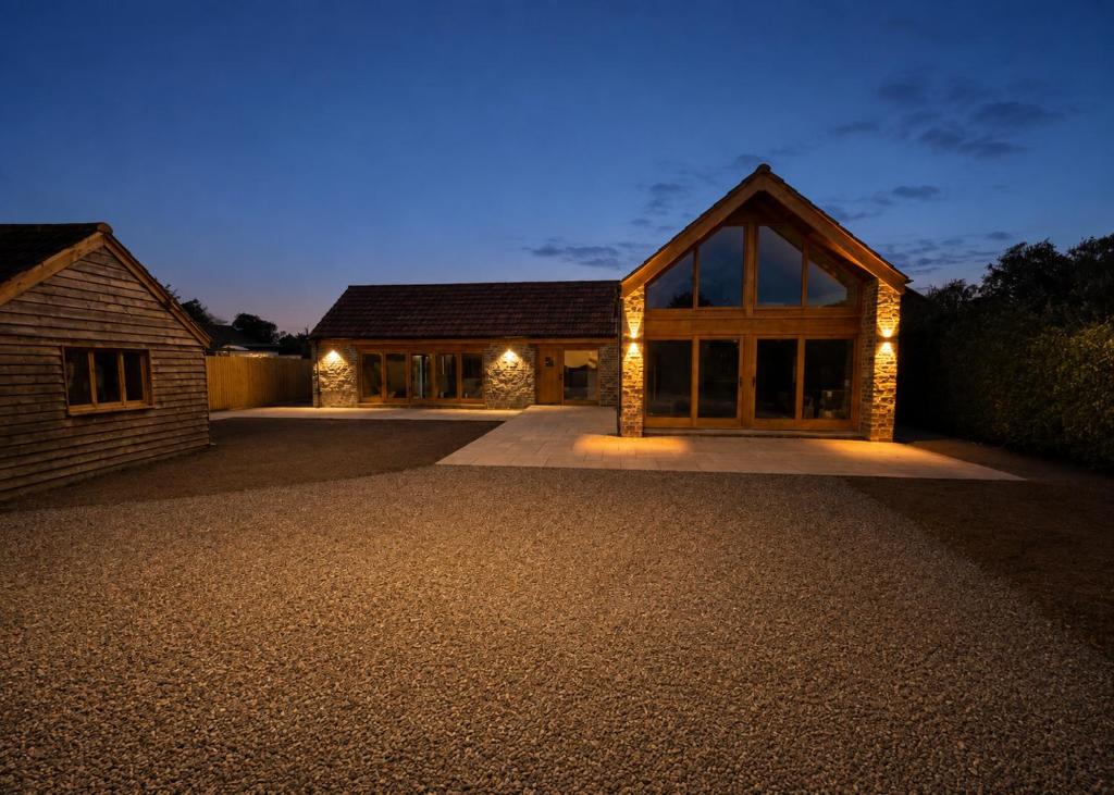 a house with lights on a driveway at night at Blackberry Barn in Baltonsborough