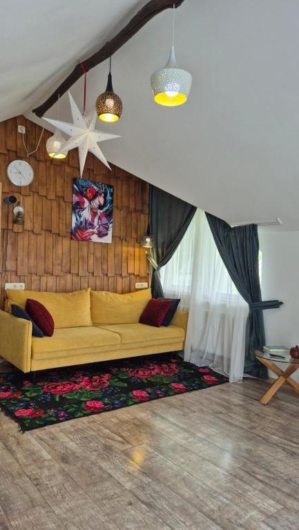 a living room with a yellow couch on a rug at GONTA kottage - БАСЕЙН,ЧАН - Джакузі in Slavske