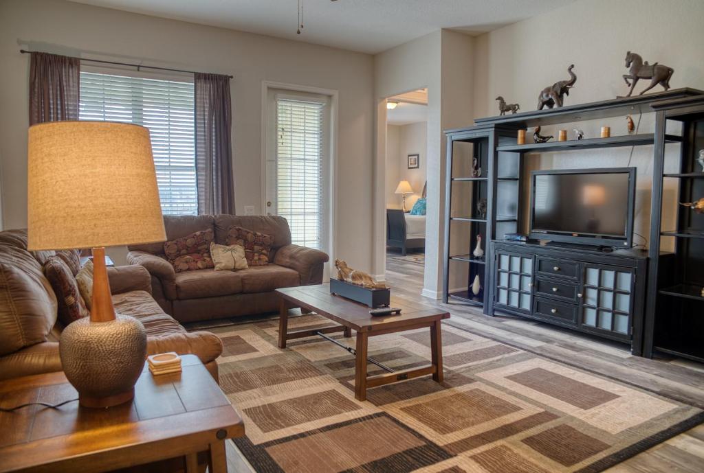 a living room with a couch and a television at Vista Cay Luxury Loft in Orlando