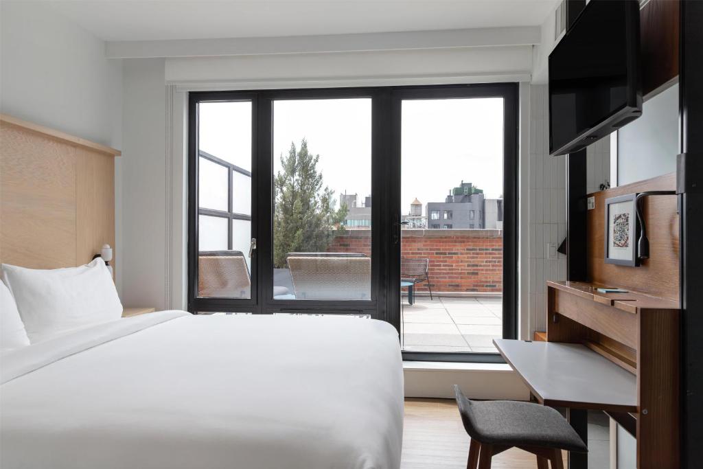ein Schlafzimmer mit einem Bett und einem großen Fenster in der Unterkunft Arlo SoHo in New York
