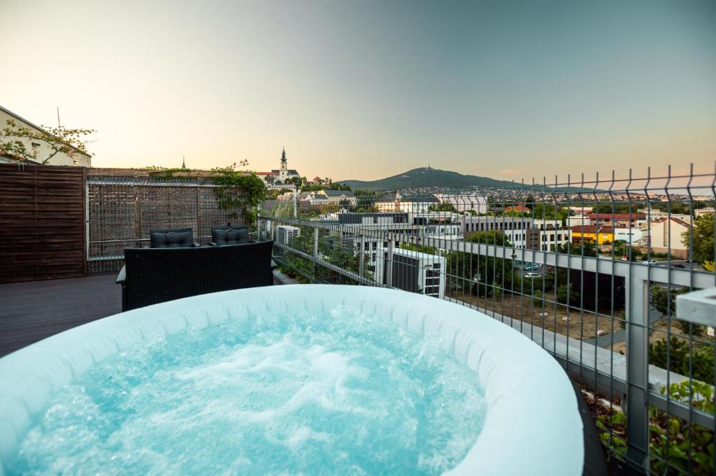 a hot tub on a balcony with a view of a city at Penthouse Centrum Nitra Jacuzzi&View, free parking in Nitra