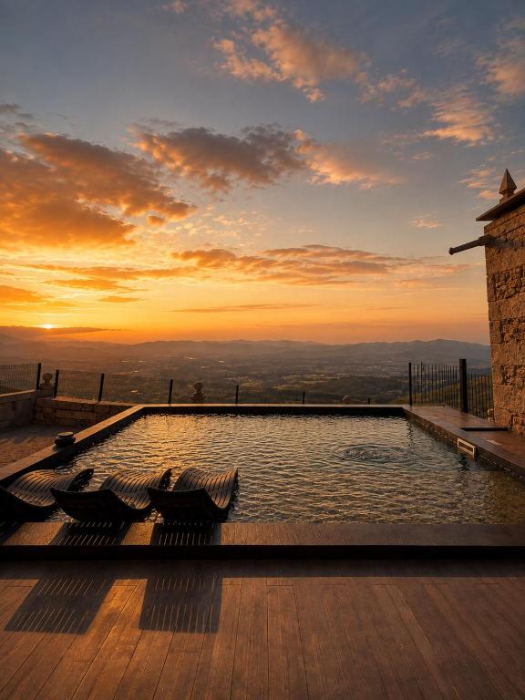 a swimming pool on top of a building with a sunset at Fagundes Village in Valença
