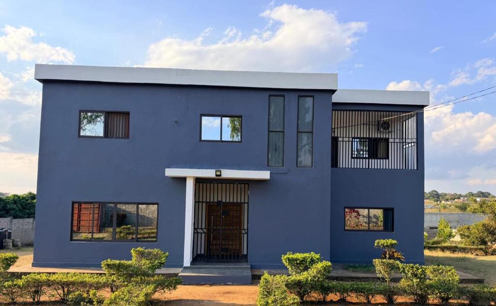 a house with a blue facade at Oikos Residencial in Chimoio