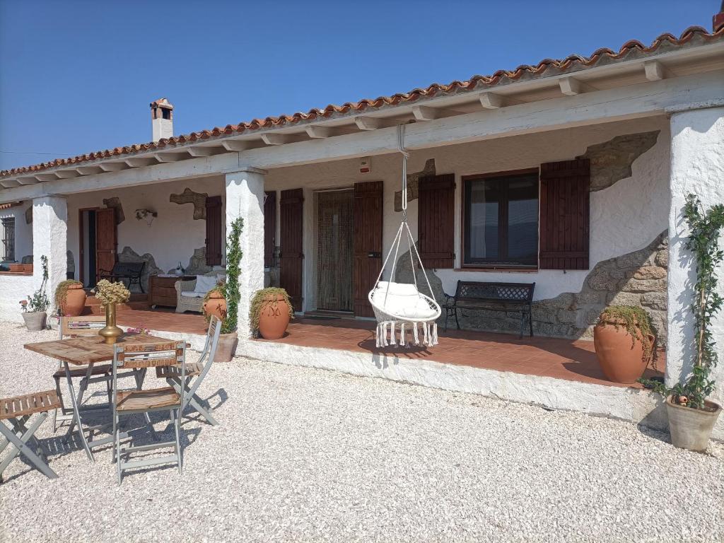 a patio of a house with a table and chairs at Funtana e Caddos apartment in Berchidda
