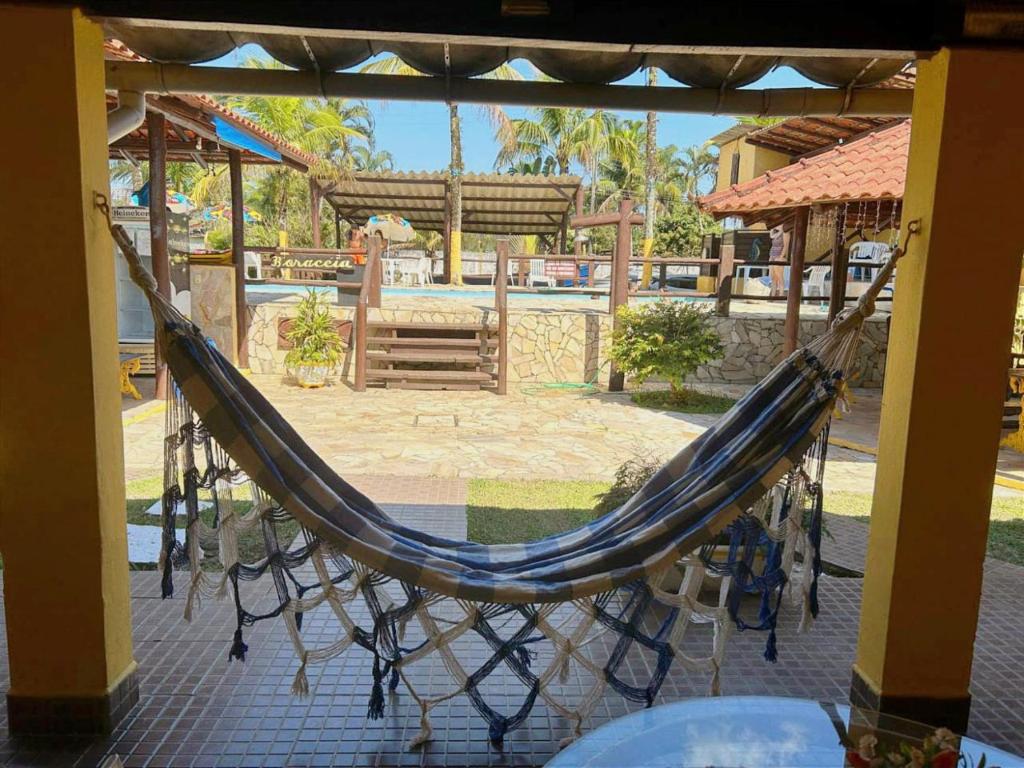 a hammock in a pavilion with a pool at Pousada dos Pescadores in Bertioga