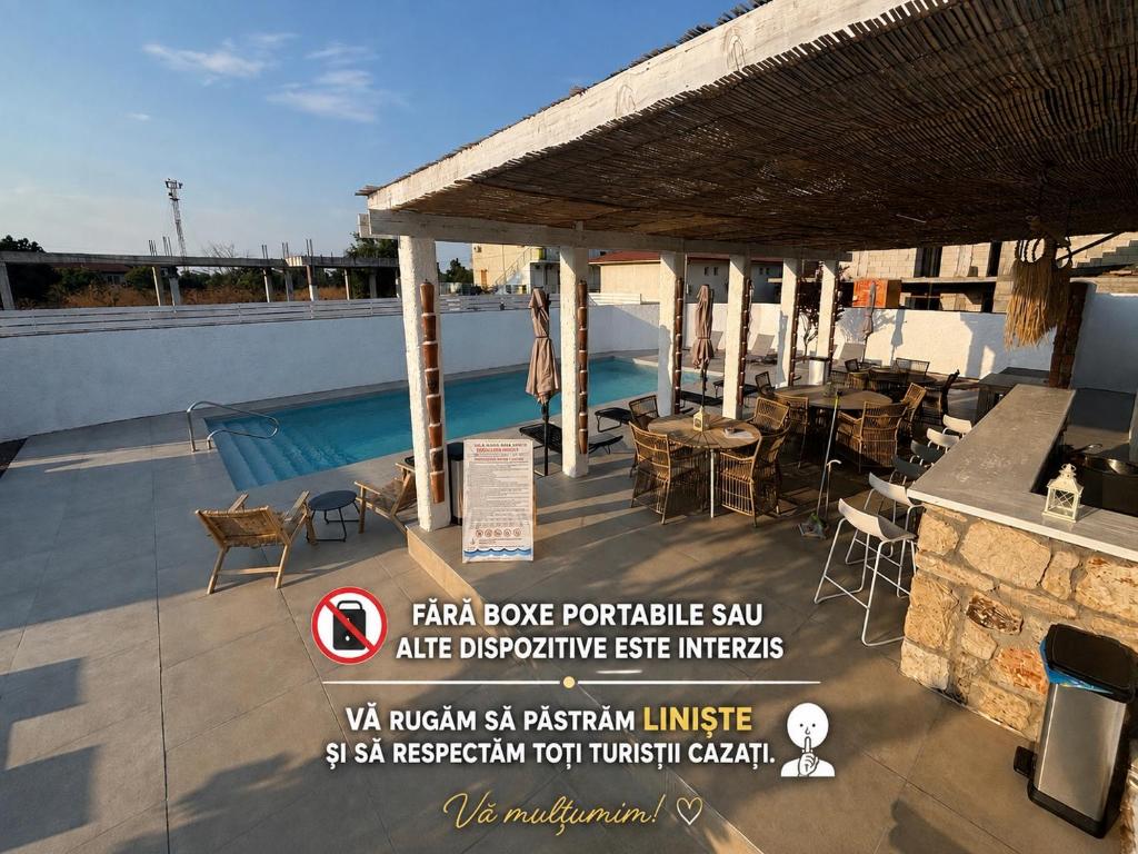 a patio with a table and chairs on a roof at Vila Alaris Vama Veche in Vama Veche