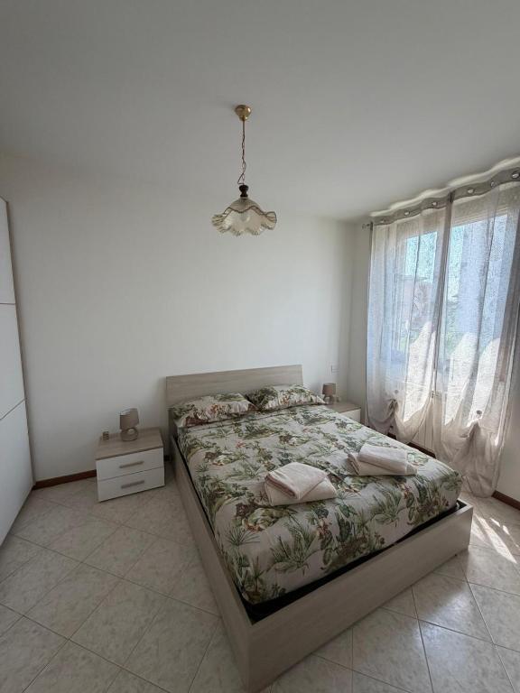 a bedroom with a bed and a chandelier at Ambra House in Piacenza