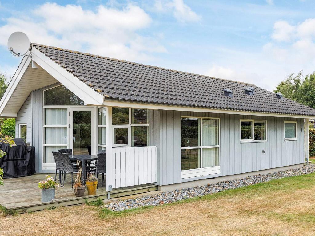 a small white cottage with a table in a yard at 6 person holiday home in Væggerløse-By Traum in Bøtø By