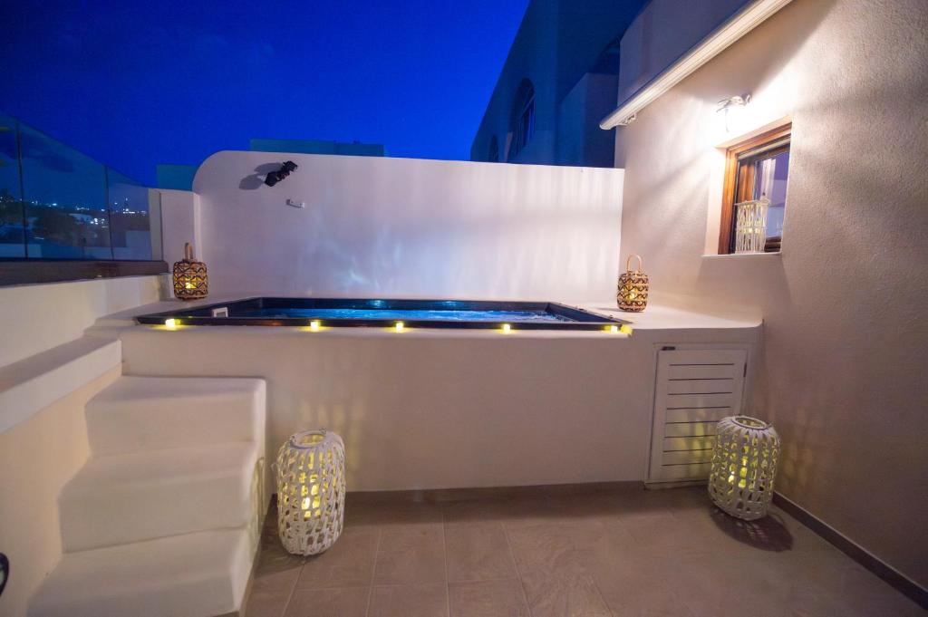 a jacuzzi tub in a room with lights at GRAND HAYAT VILLA Santorini in Mesaria