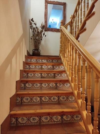 a staircase with a mirror and a vase of flowers at Casa Flor de Rello in Rello