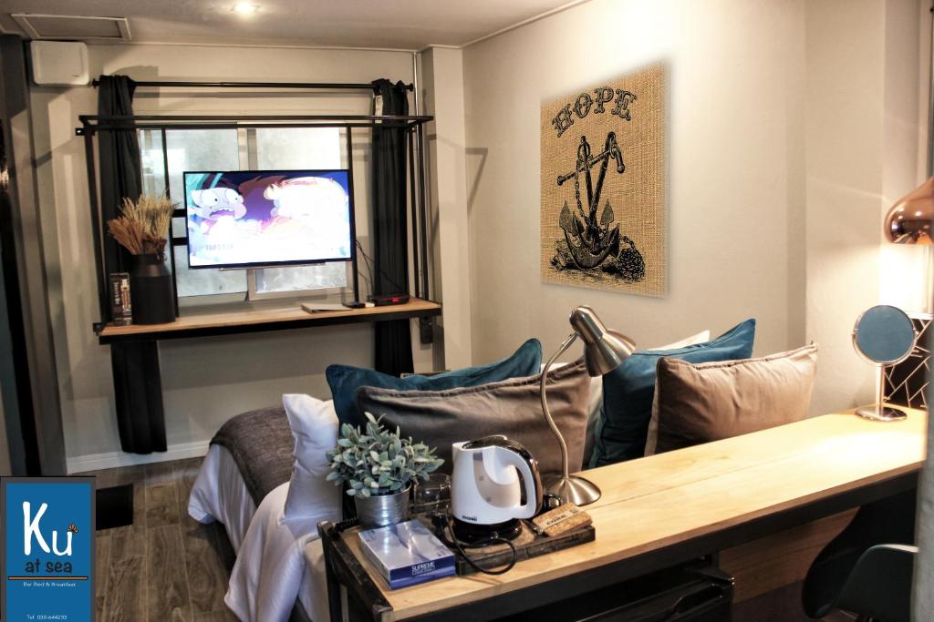 a living room with a couch and a tv at Ku at sea in Ko Samed