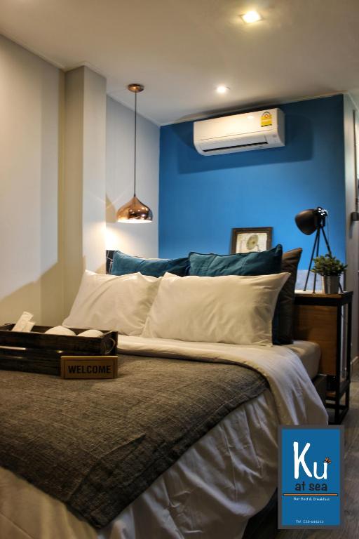 a bedroom with a bed with a blue wall at Ku at sea in Ko Samed