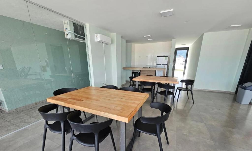 a group of tables and chairs in a room at Paseo Cibeles departamento in Villa Carlos Paz