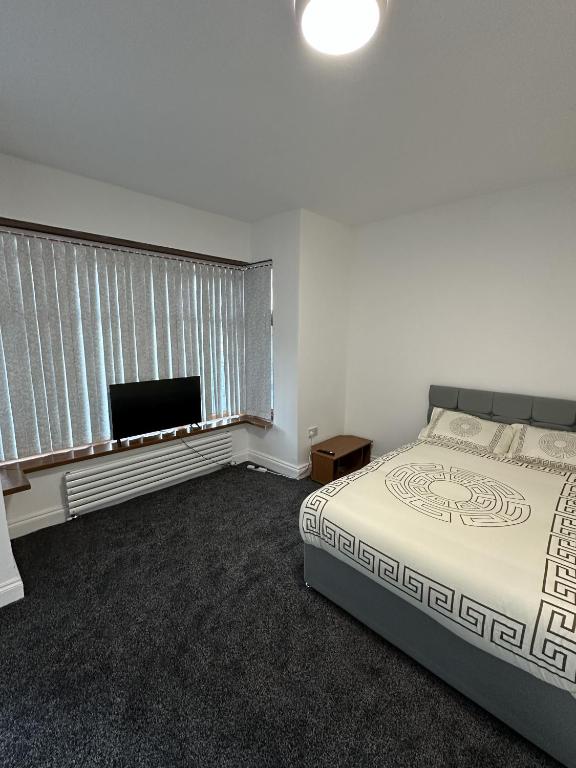 a bedroom with a bed and a flat screen tv at Plus Properties Leeds 3 in Bradford