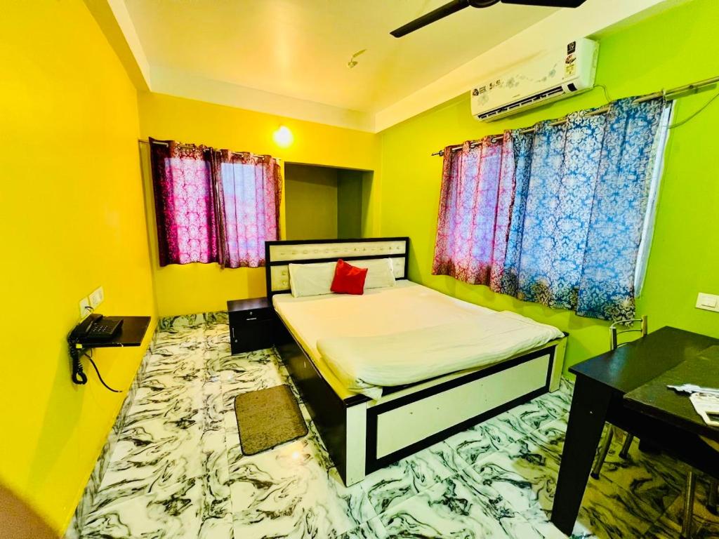a small room with a bed and a desk at Radha Rani lodge in Siliguri