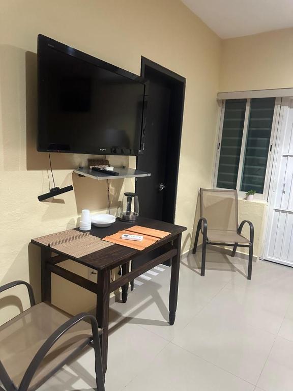 a living room with a table and a flat screen tv at Casa Victoria in Colima