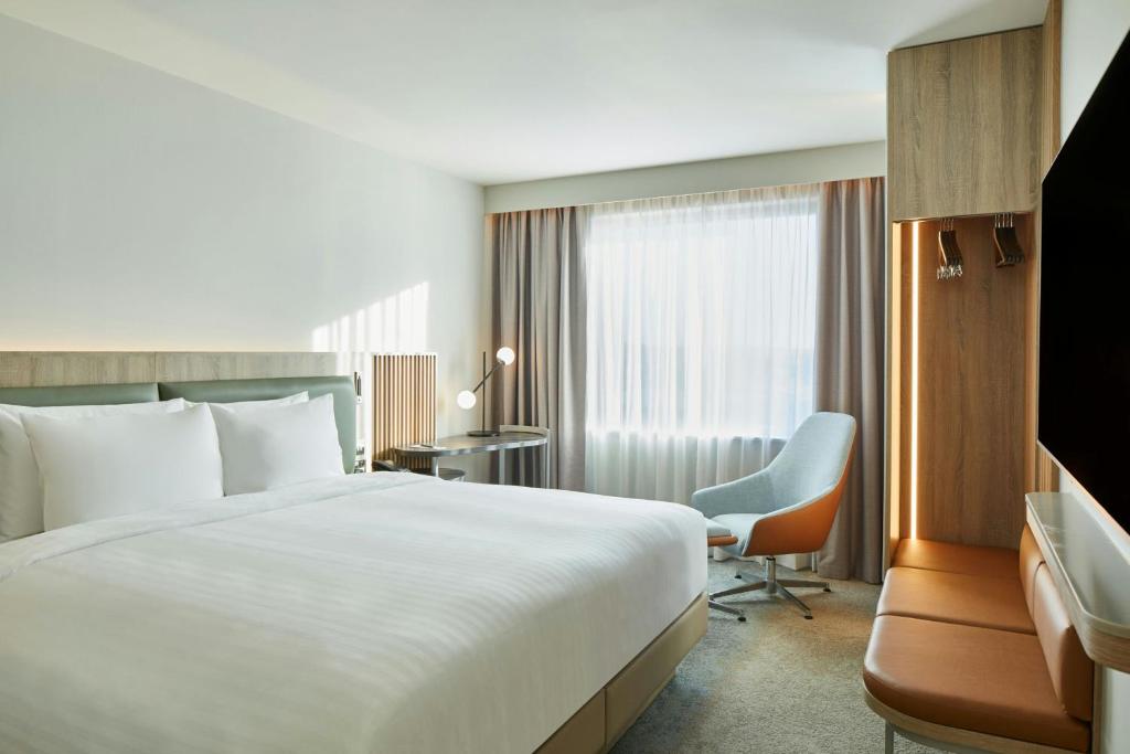 a hotel room with a large bed and a chair at Courtyard by Marriott Sheffield in Sheffield