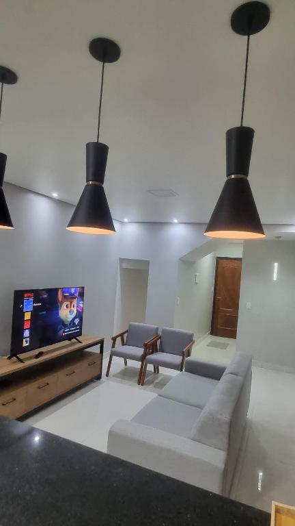 a living room with a couch and a tv and lights at Apartamento completo 2 quartos in Brasília