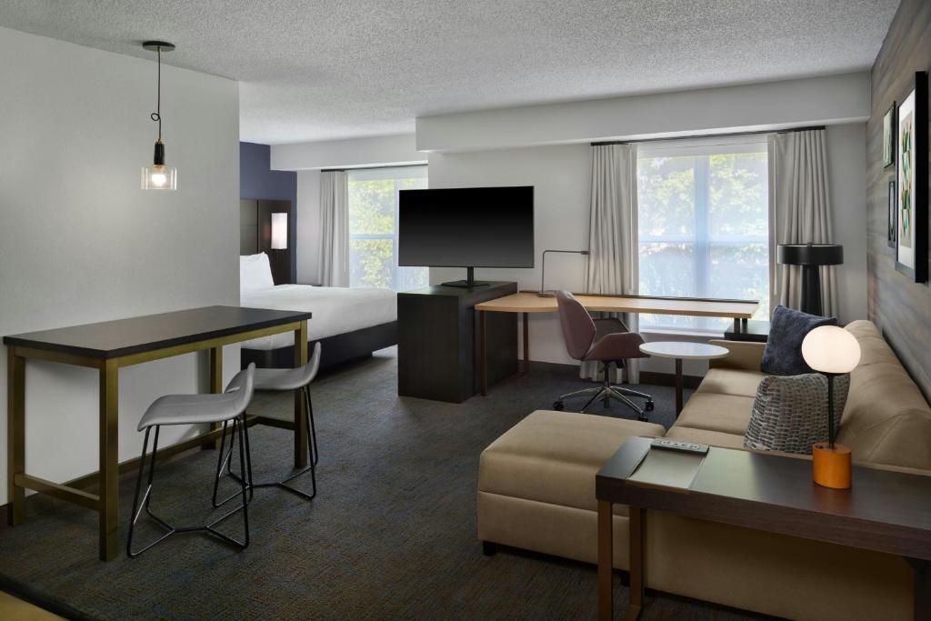 a hotel room with a bed and a living room at Residence Inn by Marriott Flint Grand Blanc in Flint