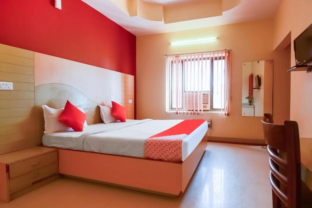 a bedroom with a bed and a red wall at Hotel Samar Palace Near Sodala Vivek Vihar Metro Station in Jaipur