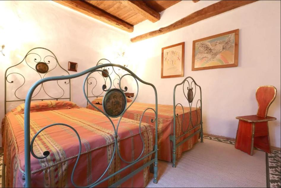 sypialnia z 2 łóżkami i stołem z krzesłem w obiekcie COLVAGO IL PIOL - ANCIENT VENETIAN VILLA w mieście Santa Giustina